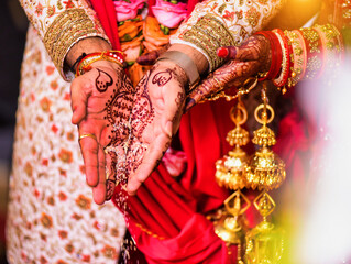 Closeup of hands with henna tattoos during an Indian traditional wedding ceremony