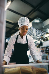 Wall Mural - African American chef preparing food at restaurant kitchen.