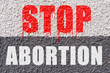 On the white-gray surface of the wall is the inscription - Stop abortion