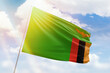 Sunny blue sky and a flagpole with the flag of zambia