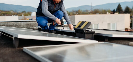 Wall Mural - Worker installing new solar panels on roof of family house. Alternative energy. Cover photo