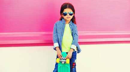 Wall Mural - Portrait of little girl child posing with skateboard in the city