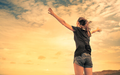 Happiness and freedom in nature. Happy woman with arms outstretched to the beautiful sunset. 