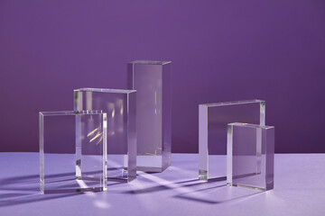 Front view of transparent podium decorated in purple background 