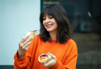 Wall Mural - A young smiling girl holds vegetarian rolls.