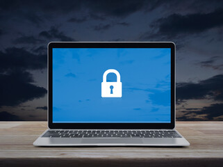 Padlock flat icon on modern laptop computer monitor screen on wooden table over sunset sky, Technology internet cyber security and safety online concept