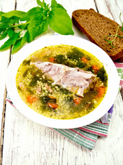 Poster - Soup with couscous and spinach in plate on board