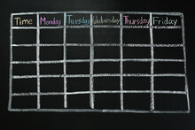 Weekly School Timetable Drawn On Black Chalkboard