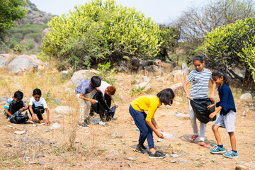 group of volunteer kids collecting plasting carbage at forest during summer camp vocation - concept 