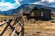 Old western house in a field with mountains in the background in Cody, Wyoming