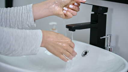 Wall Mural - Hands of a Caucasian woman washing her hands