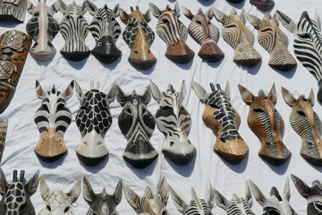 Closeup of giraffe and zebra head wood carvings displayed at a souvenir shop in Egypt