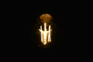 Canvas Print - Details of a light bulb and a black background