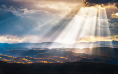 Canvas Print - Scenic view of hills and mountains filled with evening sunrays