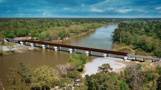 Aerial view of a railroad bridge over the lake Houston surrounded by forest