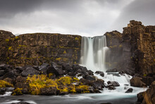 Gorgeous View Of The Skogafoss Waterfall In Iceland With Silky Water Running Down Mossy Rocks