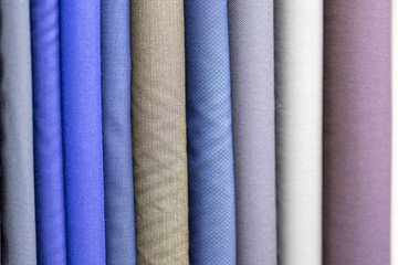 Blue, brown and gray bolts of fabric for making suits by a tailor