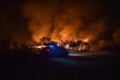 Bomberos trabajando durante un incendio forestal. Fuego y llamas amenazan el bosque, los arboles y el medio ambiente, Noche y llamas, riesgo y personal de emergencias.
