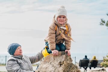 grandmother and granddaughter go in for sports on stones in the open air to maintain health, cohesion. the concept of. lifestyle in the older generation and family, playing sports together