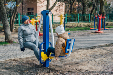 grandmother and granddaughter go in for sports on simulators outdoors to maintain health, cohesion. the concept of a healthy lifestyle in the older generation and family, playing sports together