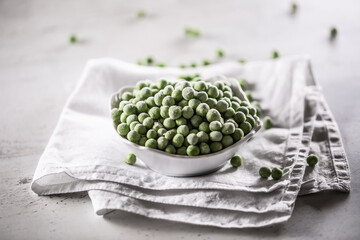 Wall Mural - Frozen peas in a white porcelain bowl.