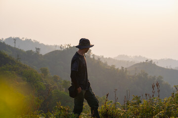 Canvas Print - silhouette hiker man relax on mountain with sunset background
