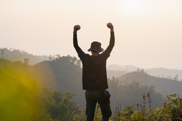 Canvas Print - silhouette hiker man relax on mountain with sunset background