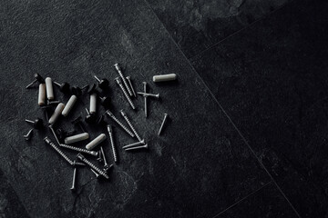 Poster - close-up photo of assorted screws for furniture assembly on the wooden table