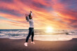 © Gennaro Leonardi - Jump on the beach at sunset. Girl jumps for joy during sunset on the beach by the sea. Concept of happiness and beauty of nature.