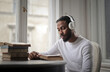 © olly - young man studying listening to music