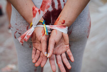  Demonstration Protest Against Rape And Cruelty In Ukraine During The War. Hands Tied Behind Back, Clothes Covered In Blood. Imitation Of A Victim. Cruelty And Violence In Ukraine During The War. 