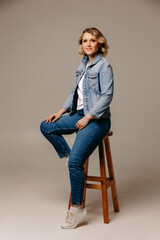 woman sitting on a chair, portrait of a woman, happy woman in red background, portrait of blonde woman.