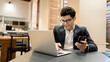 © muse studio - The manager is a man in glasses business suit working in the office, writes a message to the partner by e-mail