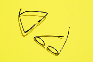 Different stylish eyeglasses on yellow background