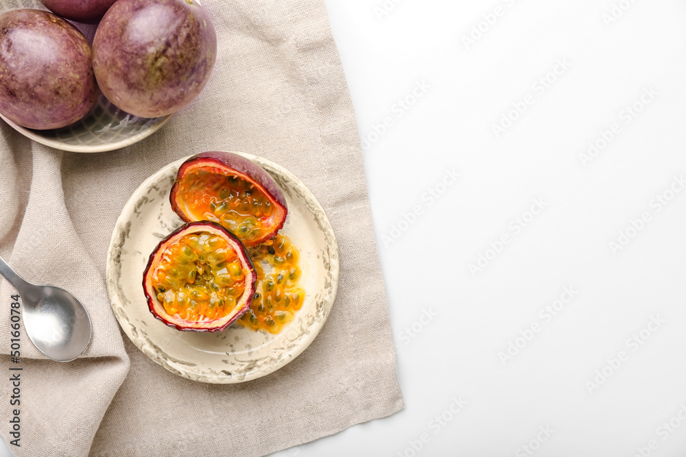 Plate with delicious passion fruits on white background