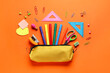 © Pixel-Shot - Pencil case with school stationery on orange background, flat lay