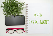 Writing Displaying Text Open Enrollment. Business Approach The Yearly Period When Showing Can Enroll An Insurance Office Supplies Over Desk With Keyboard And Glasses And Coffee Cup For Working