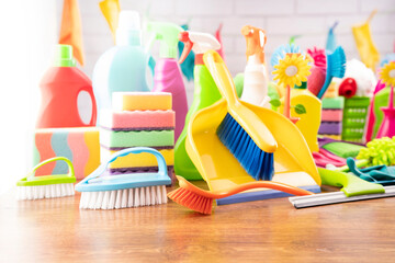 Spring house cleaning. Colorful cleaning kit on white wall background.