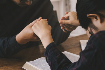 Wall Mural - Two lovers Pray for god blessing to wishing have a better life. woman hands praying to god with the bible. begging for forgiveness and believe in goodness. Christian life crisis prayer to god.