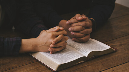 Wall Mural - Two lovers Pray for god blessing to wishing have a better life. woman hands praying to god with the bible. begging for forgiveness and believe in goodness. Christian life crisis prayer to god.