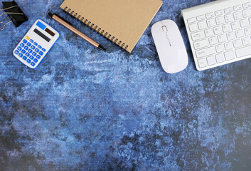 Poster - Desk with an empty notebook, a keyboard, and different office equipment. In the top view, copy space