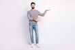 © Tetiana - Full length photo of young man indciate fingers empty space ad promo choice isolated over grey color background