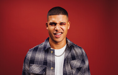 Handsome young man winking in a studio