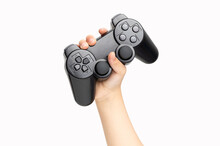 Shot Of An Little Boy Hand Holding Black Gamepad Show Cool Symbol On White Background, Minimalism Concept.