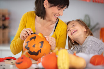 happy playful mother and daughter during halloween