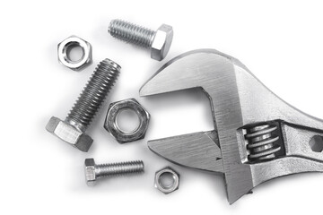 Top view on adjustable wrench and bolts with nuts on white background