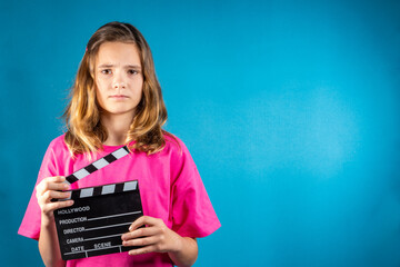 Serious girl with a clapperboard gives a signal about the start filming. Concept of cinematography, synchronization of sound and video, training directors and operators, cinema network