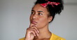 © Marco - Young black woman thinking looking for solution to a problem, looks at camera