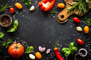 Wall Mural - Food frame. Food cooking background on black stone table. Fresh vegetables, herbs and spices. Top view with copy space.