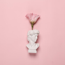 Romantic Minimal Still Life. David Bust With Flower Isolated On Pink Background